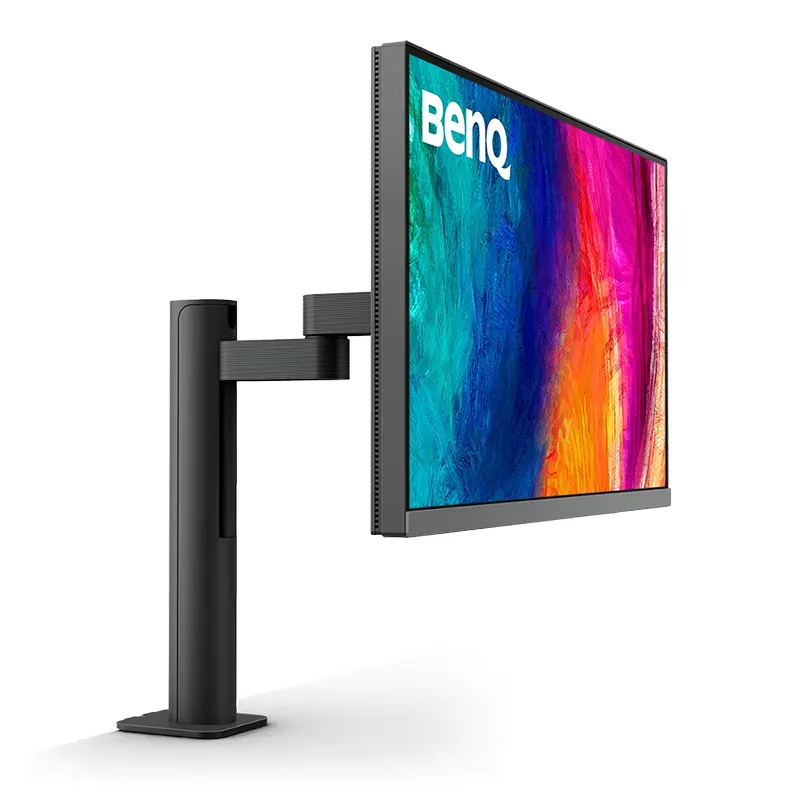 BenQ PD2706UA monitor displaying M-Book mode color calibration side-by-side with a MacBook Pro laptop.